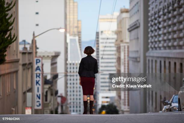 businesswoman standing on top of steep san francisco street and looking out - san francisco street stockfoto's en -beelden