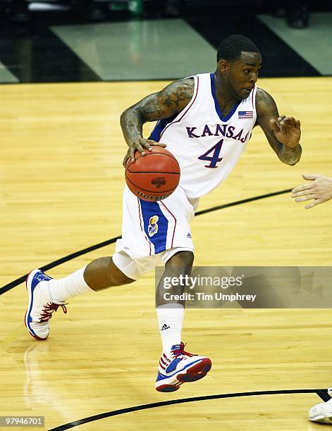 Sherron Collins of the Kansas Jayhawks tries to dribble around the defense of the Texas Tech Red Raiders during the quarterfinals of the 2010...