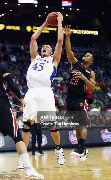 Cole Aldrich of the Kansas Jayhawks grabs a rebound over John Roberson of the Texas Tech Red Raiders during the quarterfinals of the 2010 Phillips 66...