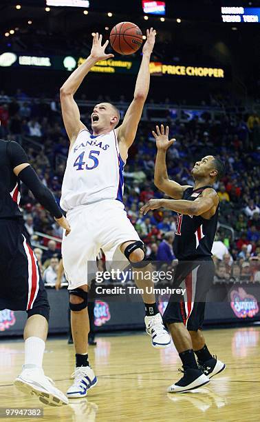 Cole Aldrich of the Kansas Jayhawks grabs a rebound over John Roberson of the Texas Tech Red Raiders during the quarterfinals of the 2010 Phillips 66...