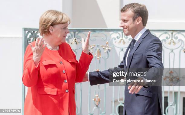 June 2018, Germany, Meseberg: German Chancellor from the Christian Democratic Union , Angela Merkel, gesticulating next to the French President,...