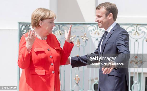 June 2018, Germany, Meseberg: German Chancellor from the Christian Democratic Union , Angela Merkel, gesticulating next to the French President,...