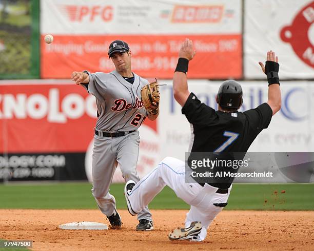 Infielder Scott Sizemore of the Detroit Tigers starts a double play over sliding outfielder Jeremy Reed of the Toronto Blue Jays March 22, 2010 at...