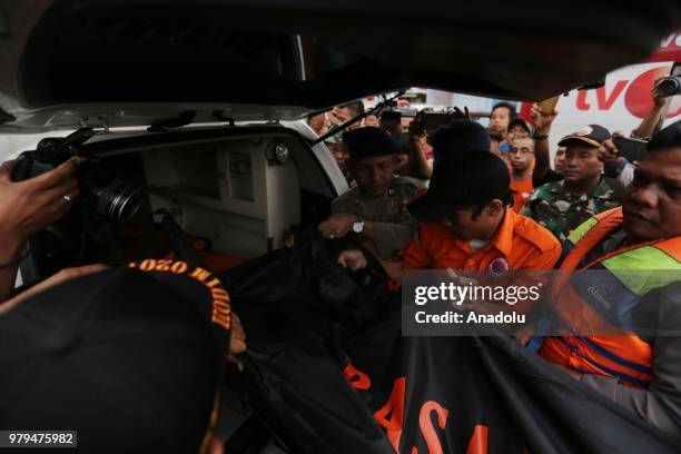 Officer holds a body bag from a Sinar Bangun Motor Vessel victim who sank a few days ago in Lake Toba, in North Sumatra on June 20, 2018. Recorded to...