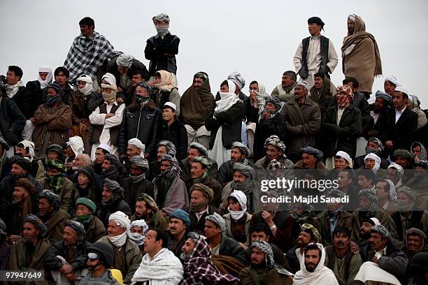 Afghan tribesmen watch a game of Buzkashi, a traditional sport played on horseback, during celebrations for the solar-based New Year's or Nowruz, on...