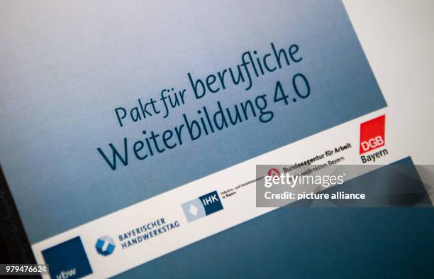 June 2018, Germany, Munich: A certificate reading 'Pakt fuer berufliche Weiterbildung 4.0' lies on a table prior to its signing at the...