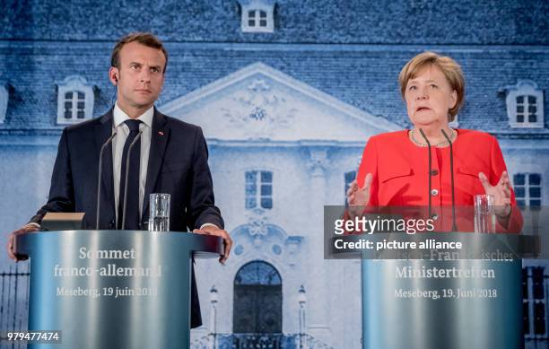 June 2018, Germany, Meseberg: German Chancellor Angela Merkel of the Christian Democratic Union stands next to the President of France, Emmanuel...