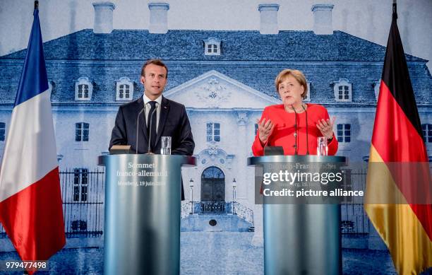 June 2018, Germany, Meseberg: German Chancellor Angela Merkel of the Christian Democratic Union stands next to the President of France, Emmanuel...