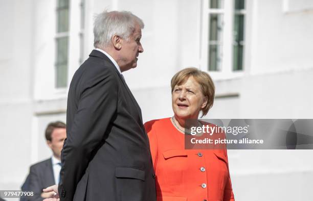 June 2018, Germany, Meseberg: German Chancellor Angela Merkel of the Christian Democratic Union speaks with Horst Seehofer, German Minister of the...