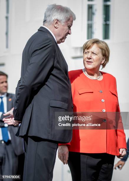 June 2018, Germany, Meseberg: German Chancellor Angela Merkel of the Christian Democratic Union speaks with Horst Seehofer, German Minister of the...