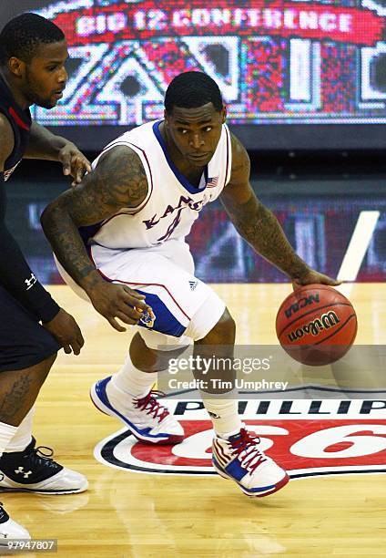 Sherron Collins of the Kansas Jayhawks tries to dribble around the defense of the Texas Tech Red Raiders during the quarterfinals of the 2010...