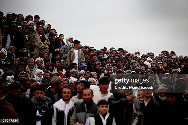 Afghan tribesmen watch a game of Buzkashi, a traditional sport played on horseback, during celebrations for the solar-based New Year's or Nowruz, on...