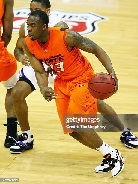 James Anderson of the Oklahoma State Cowboys tries to dribble around the defense of the Kansas State Wildcats during the quarterfinals of the 2010...