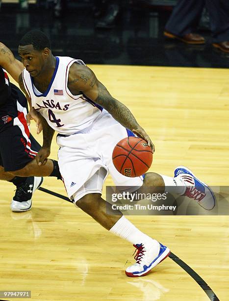 Sherron Collins of the Kansas Jayhawks tries to dribble around the defense of the Texas Tech Red Raiders during the quarterfinals of the 2010...