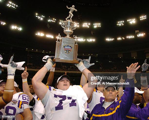 Coach Les Miles and offensive tackle Peter Dyakowski with the championship trophy after a win against Notre Dame in the Allstate Sugar Bowl at the...