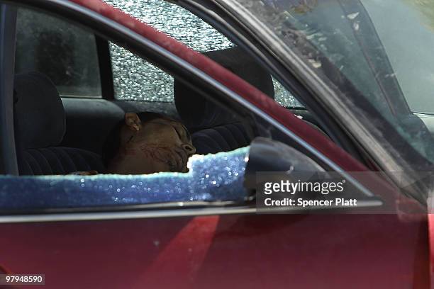 Man, one of two shot, lies dead in a car on March 22, 2010 in Juarez, Mexico. Both men, who were 18 and 34 years of age, were shot by a group of...