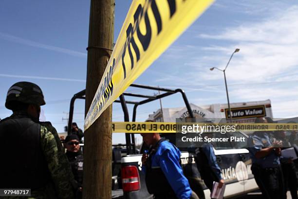 Police and military gather at a murder scene in which two men lay dead on March 22, 2010 in Juarez, Mexico. Both men, who were 18 and 34 years of...