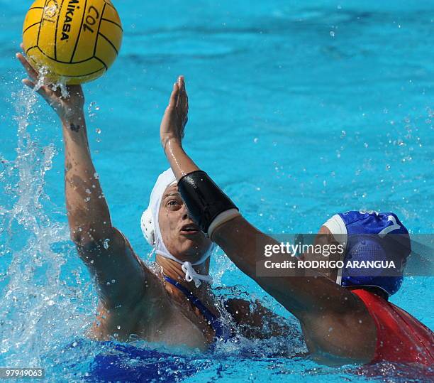 Venezuelan Rocio Galue tries to block Brazilian Flavia Vigna during the women's water-polo match at the IX South American Games in Medellin,...