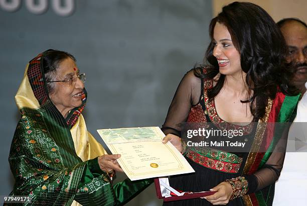 Indian president Pratibha Patil presenting the best supporting actress award to Bollywood actress Kangana Ranaut for her role in feature film...