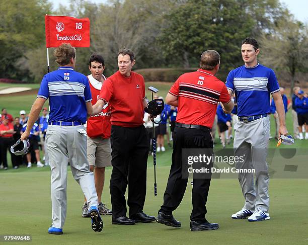 Justin Rose of England and Ian Poulter of England and the Lake Nona Team shakes hands after their win with their opponents J.B.Holmes of the USA and...