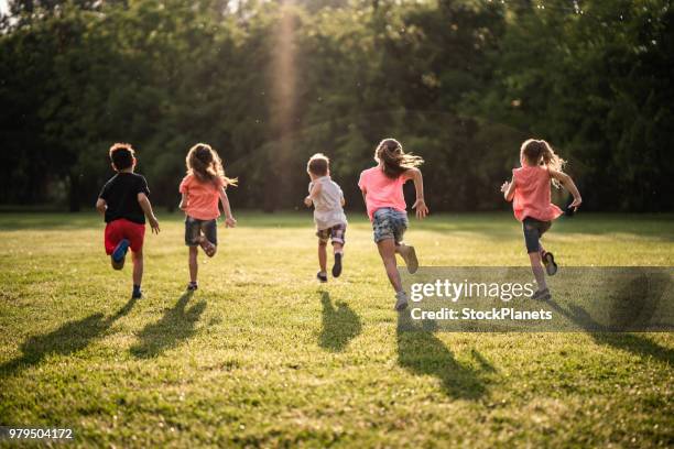 groupe de vue arrière des enfants qui courent dans la nature - preschool age photos et images de collection