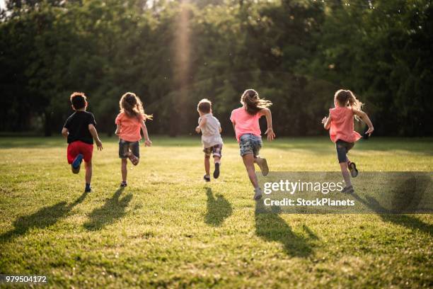 gruppo di bambini in vista posteriore che corrono nella natura - bambini che corrono foto e immagini stock