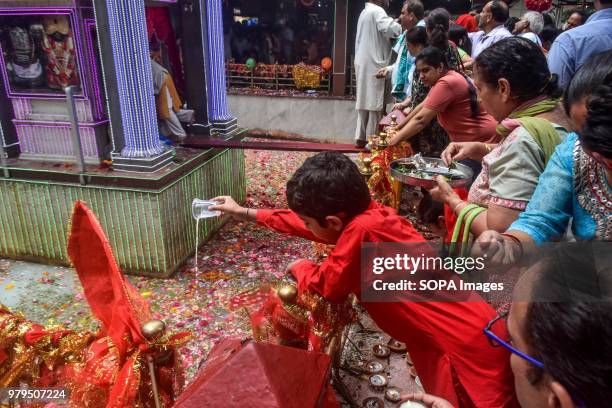 Hindu devotee pours milk into a sacred spring during the annual Hindu festival at the Kheer Bhawani Temple in Ganderbal district, some 30kms...