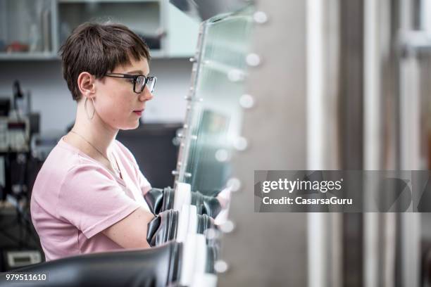 young female researcher using glove box for measuring transient photocurrent in organic semiconductors - glove box stock pictures, royalty-free photos & images