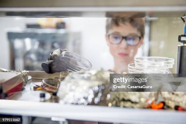young female researcher preparing samples in glove box for measuring transient photocurrent in organic semiconductors - glove box stock pictures, royalty-free photos & images