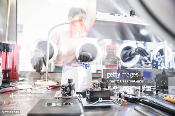 researcher working in organic semiconductors research laboratory - glove box stock pictures, royalty-free photos & images