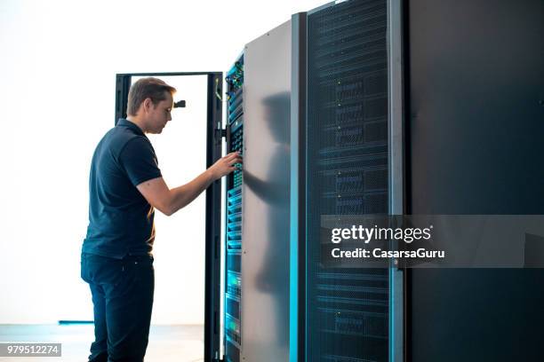 junge it techniker mainteining supercomputer - supercomputer stock-fotos und bilder