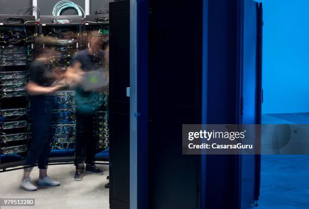 motion blur of group of it engineers in server room - super computer stock pictures, royalty-free photos & images