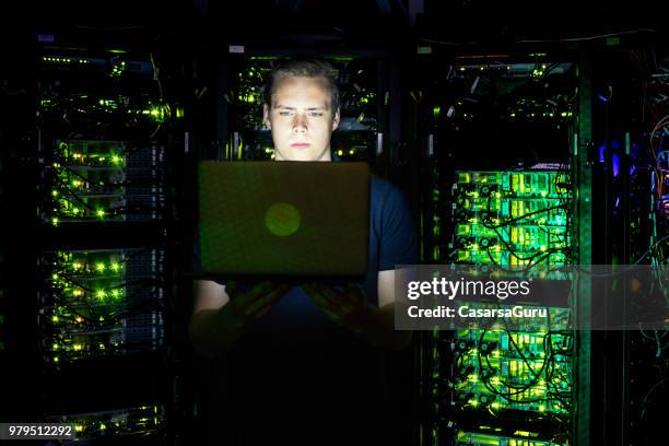 jonge man met laptop in supercomputer kamer - super computer stockfoto's en -beelden