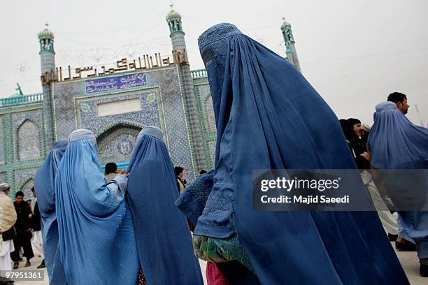 Burqa-clad Afghan women walk outside of the Hazrat-i Ali shrine in Mazar-i-Sharif, the centre of Afghan New Year's or Nauruz celebrations,, on March...