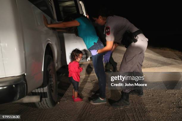 Two-year-old Honduran asylum seeker cries as her mother is searched and detained near the U.S.-Mexico border on June 12, 2018 in McAllen, Texas. The...