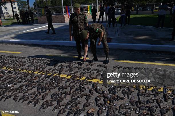 Guns seized from criminals by Brazilian armed forces are inspected by senior officials after they were crushed and destroyed at a military base in...