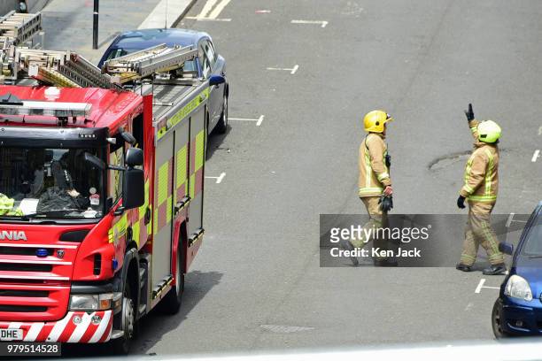 Firefighter points towards the roof of the Glasgow School of Art Mackintosh building, which was completely burned out in a major fire, still carry...
