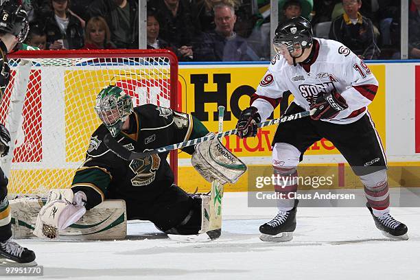 Taylor Beck of the Guelph Storm tries to tip a shot that is gloved by Michael Hutchinson of the London Knights in the first game of the opening round...