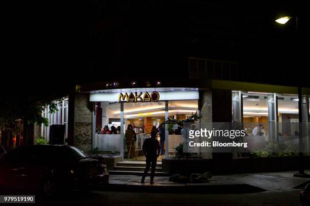 Customers eat at the Makao ice cream shop at night in the Las Mercedes neighborhood of Caracas, Venezuela, on Friday, June 15, 2018. Las Mercedes,...