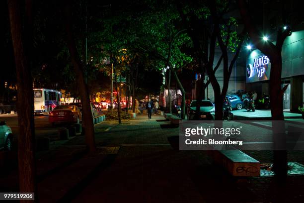 Pedestrians walk at night in the Las Mercedes neighborhood of Caracas, Venezuela, on Friday, June 15, 2018. Las Mercedes, the Caracas district known...