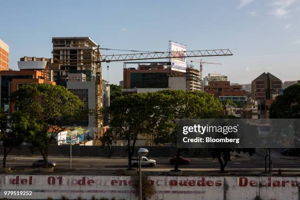 Cranes stand above buildings under construction in the Las Mercedes neighborhood of Caracas, Venezuela, on Friday, June 8, 2018. Las Mercedes, the...