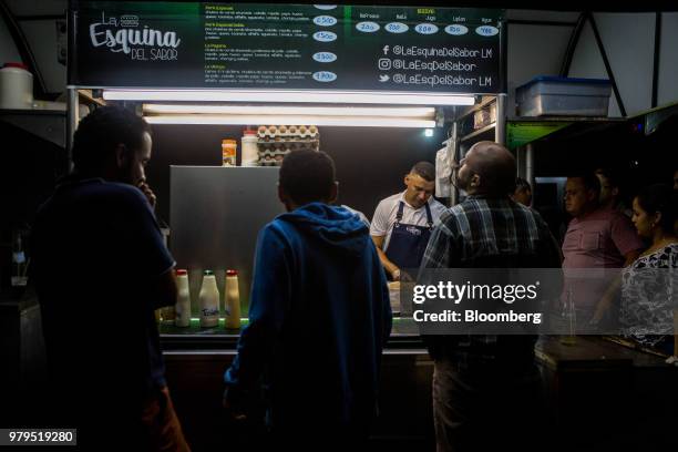 Customers order from a food truck at night in the Las Mercedes neighborhood of Caracas, Venezuela, on Friday, June 8, 2018. Las Mercedes, the Caracas...