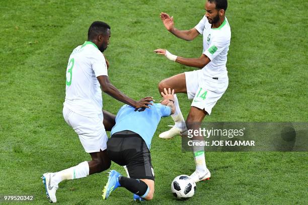 Saudi Arabia's defender Osama Hawsawi and Saudi Arabia's midfielder Abdullah Otayf fights for the ball with Uruguay's forward Luis Suarez during the...