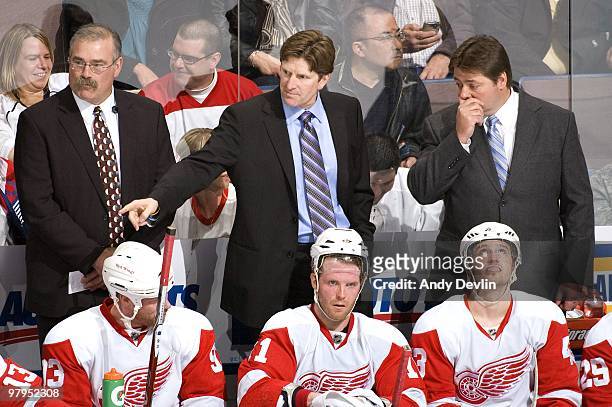 Paul MacLean, Mike Babcock and Brad McCrimmon, coaches for the Detroit Red Wings, discuss strategy during a game against the Edmonton Oilers at...