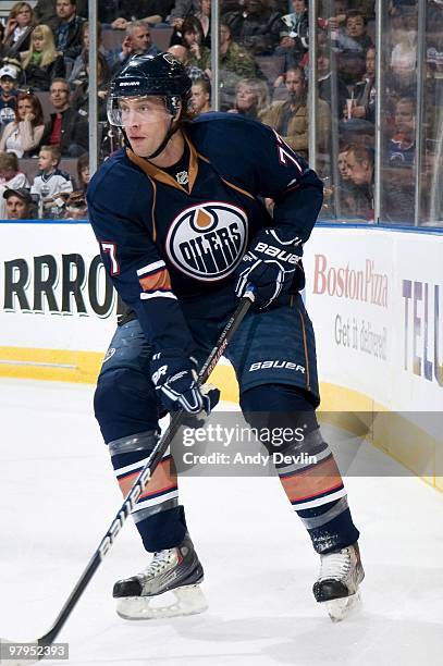 Tom Gilbert of the Edmonton Oilers handles the puck behind his own net against the Detroit Red Wings at Rexall Place on March 19, 2010 in Edmonton,...