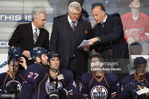 Tom Renney, Pat Quinn and Kelly Buchberger, coaches for the Edmonton Oilers, discuss strategy during a game against the Detroit Red Wings at Rexall...