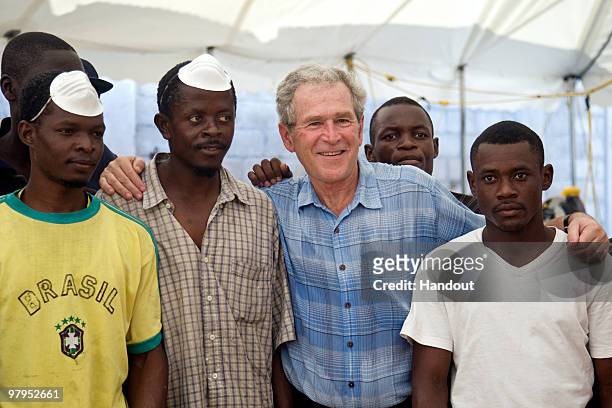 In this handout image provided by the United Nations Stabilization Mission in Haiti , Former U.S. President George W. Bush poses with workers at the...