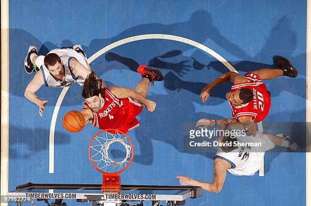 Luis Scola of the Minnesota Timberwolves shoots a layup against Kevin Love and Darko Milicic of the Houston Rockets during the game at Target Center...