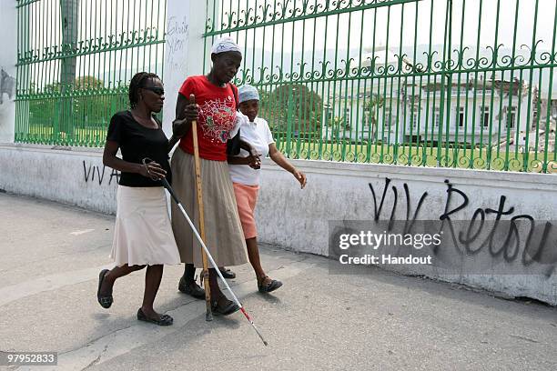 In this handout image provided by the United Nations Stabilization Mission in Haiti , A few blind women walk by the collapsed National Palace on...