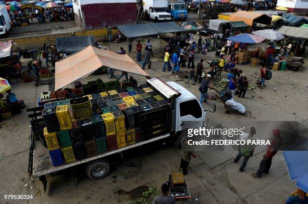 People shop at the municipal market of Coche, a neighbourhood of Caracas, on June 20, 2018. - Venezuelan President Nicolas Maduro ordered the...